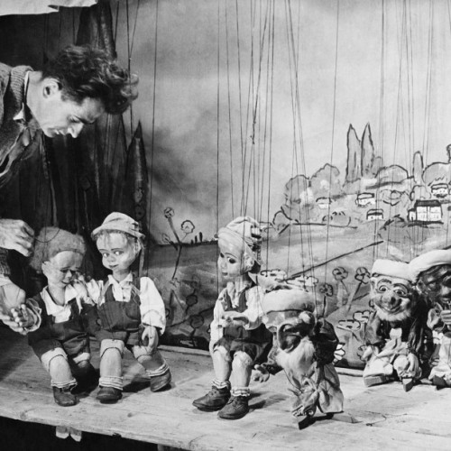 הונזו דוד בן שלום וחלק מבובות ההצגה המלך בור על רקע תפאורת הקיבוץ, שנות ה-40, אוסף עירית פטרקובסקי, באדיבות המשפחה 